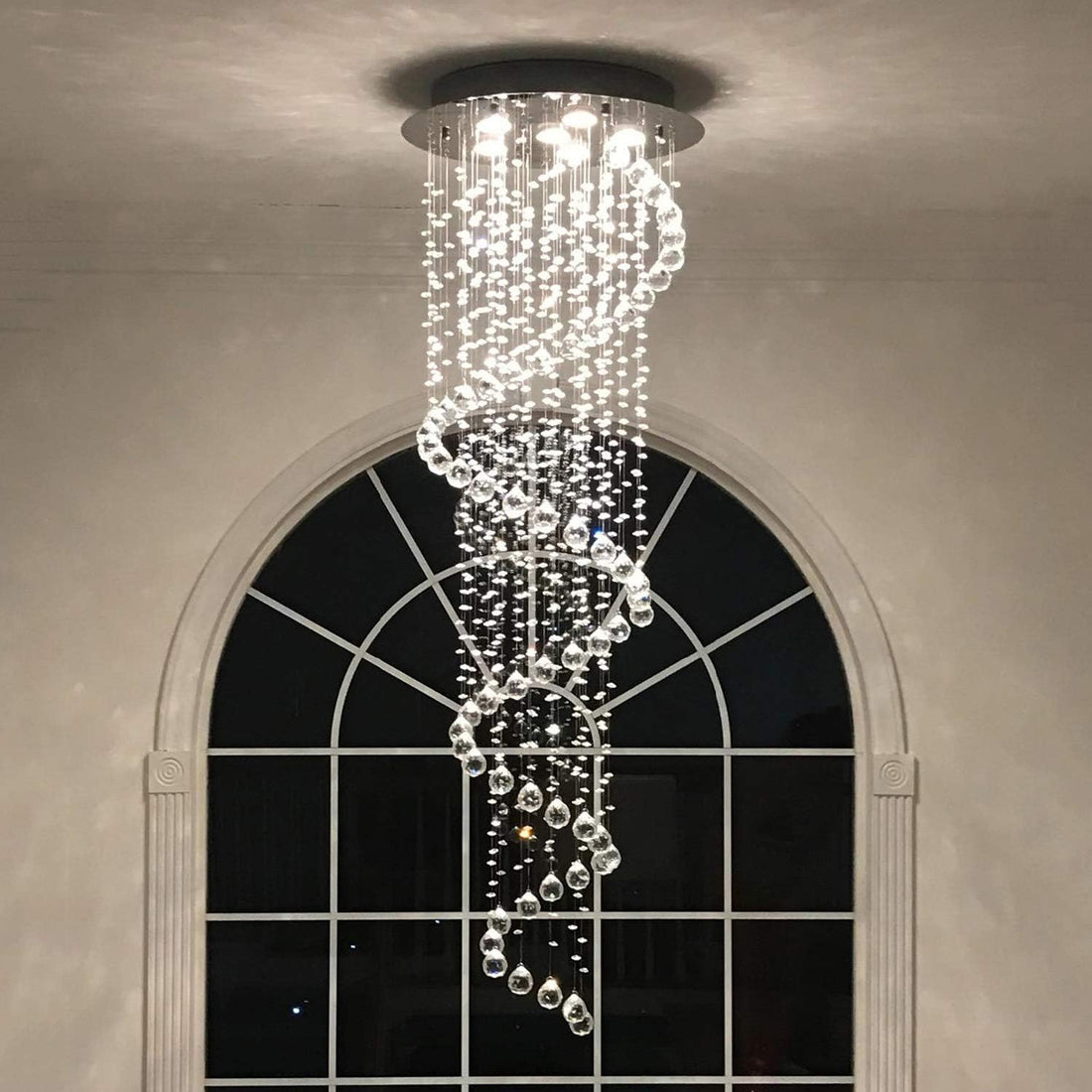 Spiral crystal chandelier hanging from a high raked ceiling in an Australian home