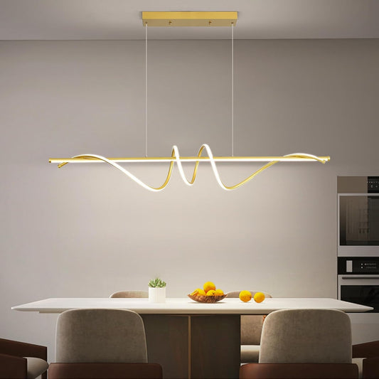 Brushed gold sculptural ribbon LED pendant light above a dining table