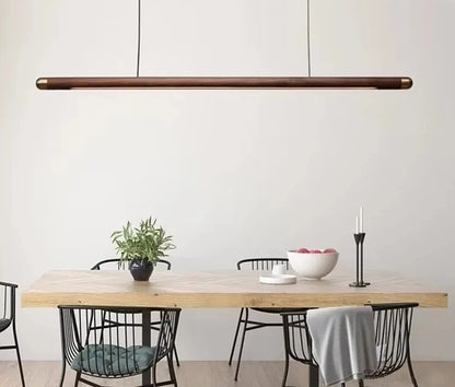 Minimalist walnut wood linear LED pendant light over a dining table in a modern Australian home