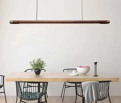 Minimalist walnut wood linear LED pendant light over a dining table in a modern Australian home