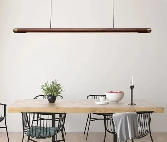 Minimalist walnut wood linear LED pendant light over a dining table in a modern Australian home