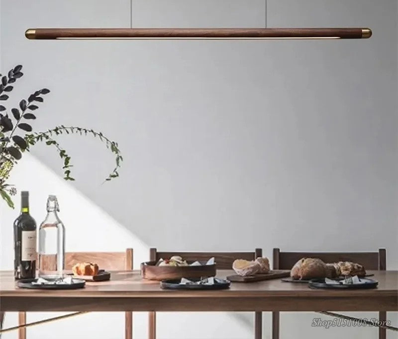 Minimalist walnut wood linear LED pendant light over a dining table in a modern Australian home